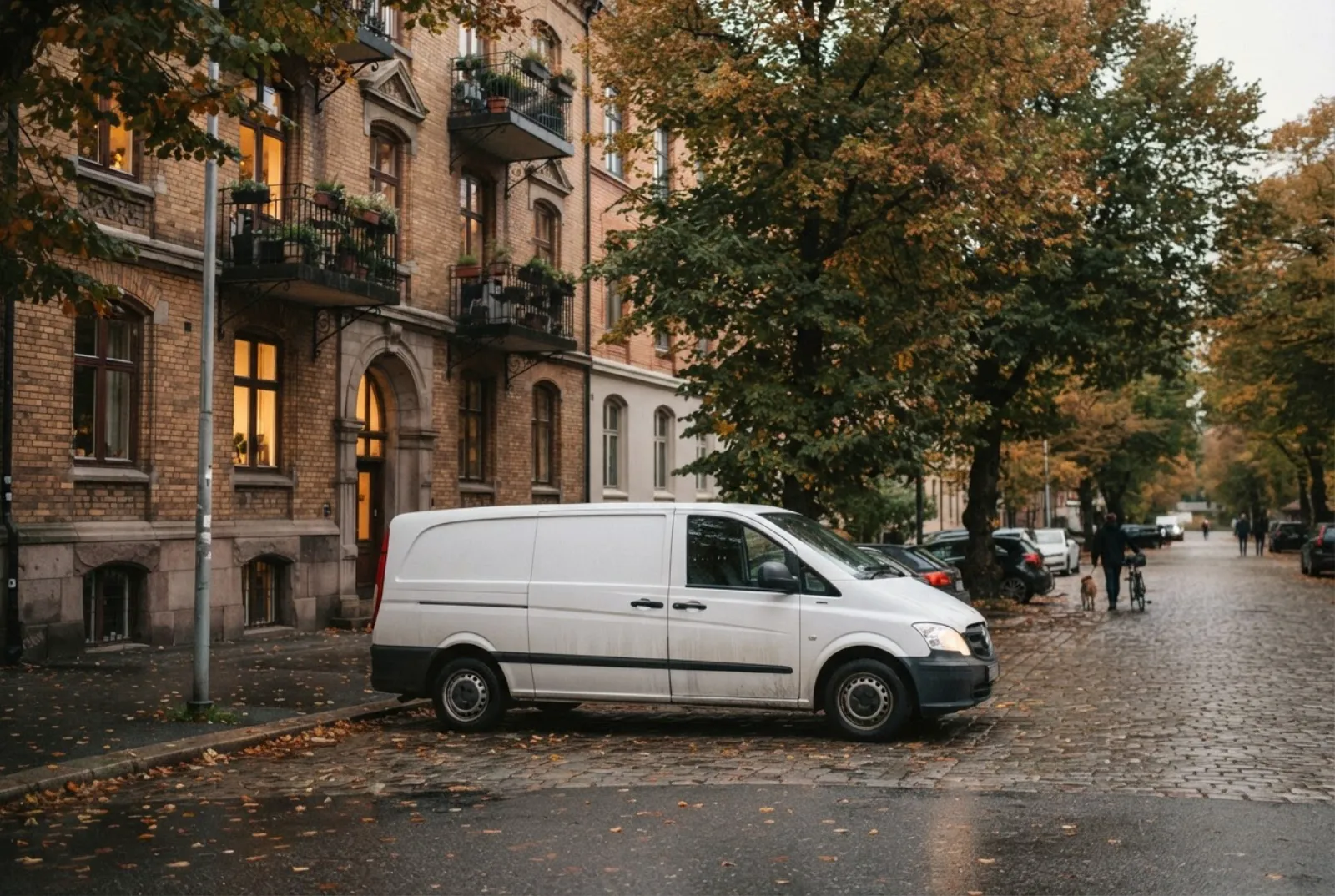 Hvit varebil uten logo parkert utenfor en bygård i Oslo om høsten